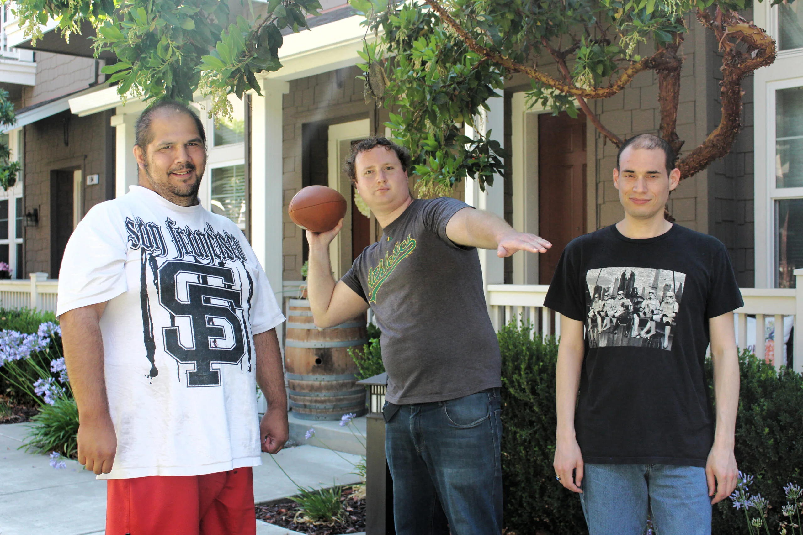Three friends outdoors holding football